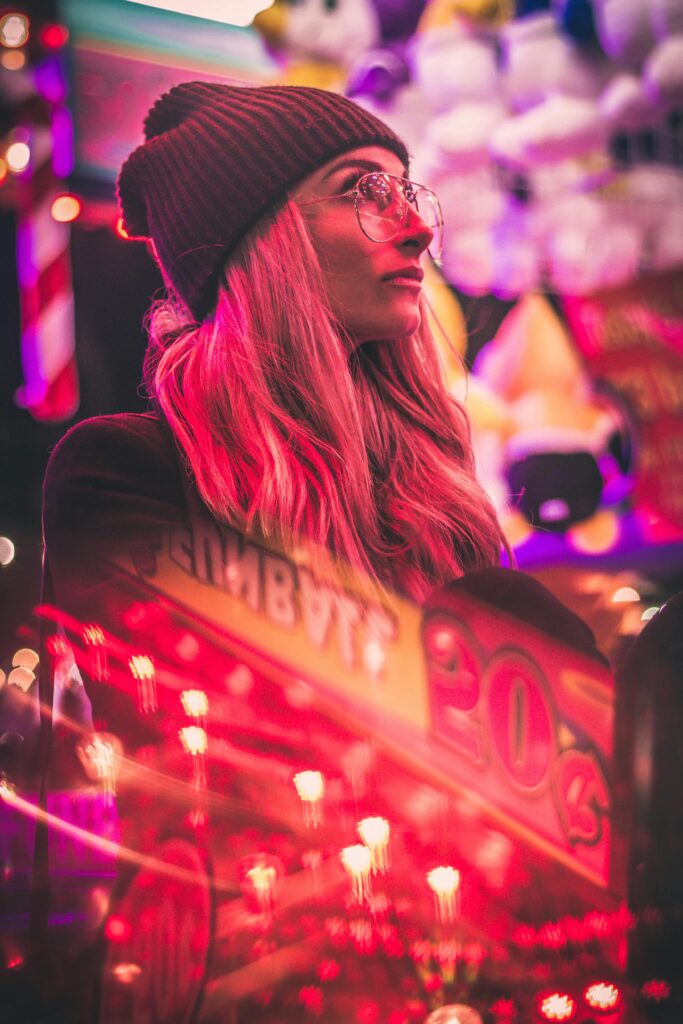pexels-photo-3090072-3090072 Stylish woman in urban setting with neon pink lights and casino reflections at night.
